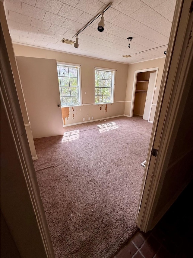 unfurnished bedroom with visible vents and dark carpet