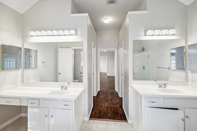 bathroom featuring tile patterned flooring, vanity, toilet, and walk in shower