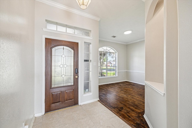 entryway featuring ornamental molding and light hardwood / wood-style floors