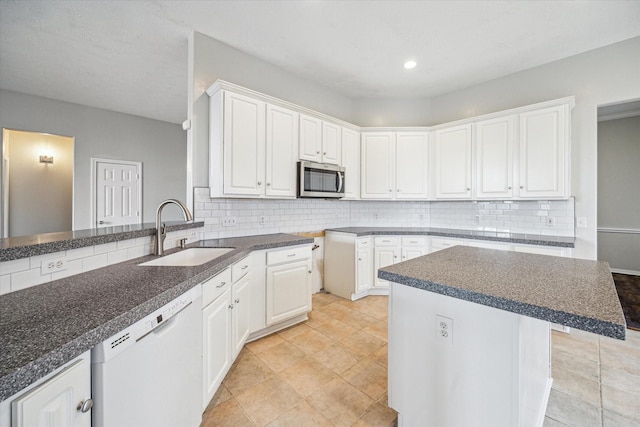 kitchen with white dishwasher, sink, white cabinetry, and backsplash