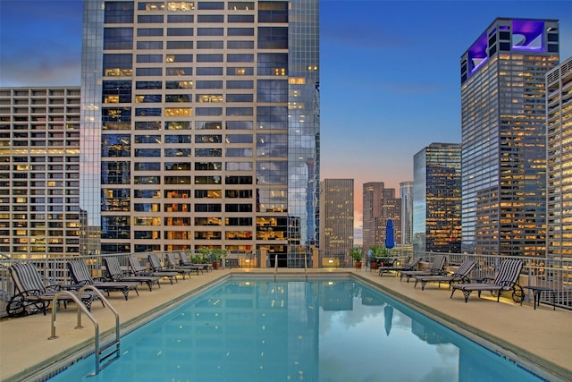 pool at dusk with a patio area