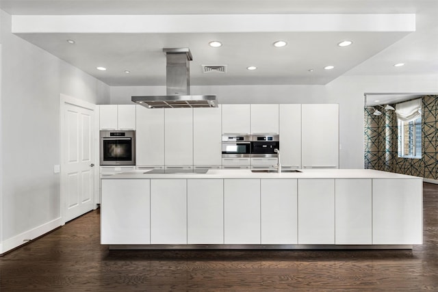 kitchen featuring white cabinetry, sink, island range hood, and a kitchen island with sink