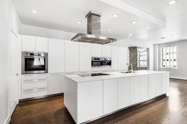 kitchen with white cabinetry, stainless steel oven, island exhaust hood, and a center island with sink