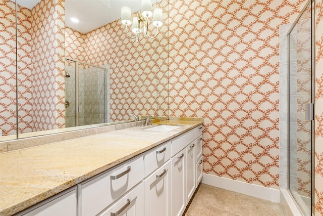 bathroom with vanity, a shower with shower door, tile patterned flooring, and a notable chandelier