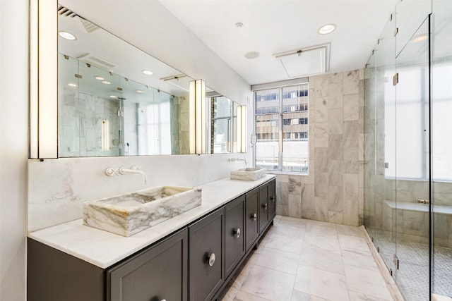 bathroom with vanity, an enclosed shower, and tile walls