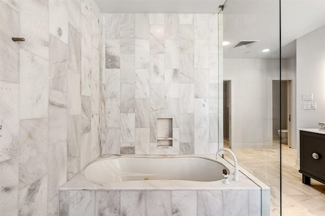 bathroom featuring vanity and tiled bath