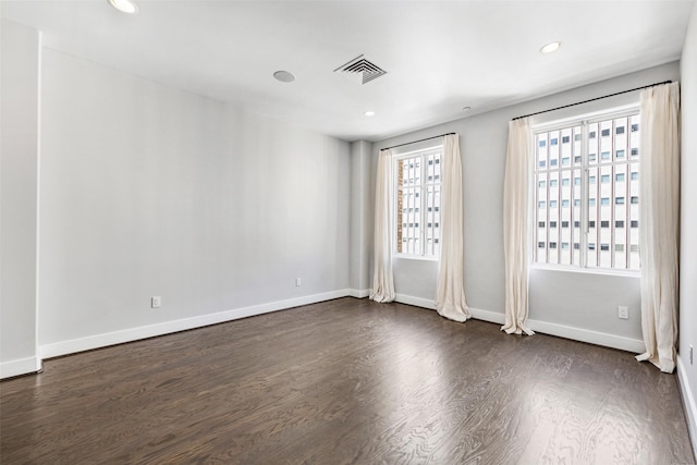 empty room featuring dark hardwood / wood-style flooring and plenty of natural light