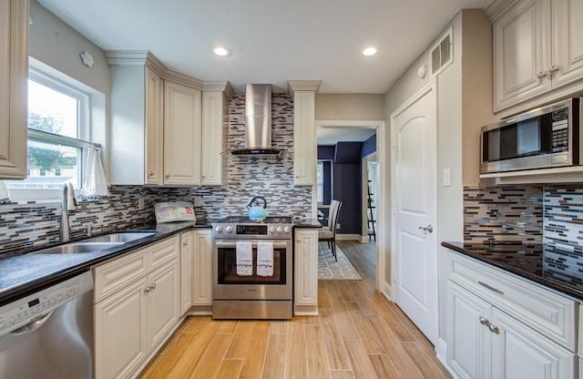 kitchen with tasteful backsplash, wall chimney range hood, stainless steel appliances, and sink