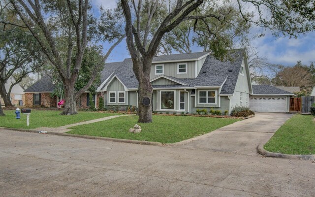 view of property featuring a garage and a front lawn