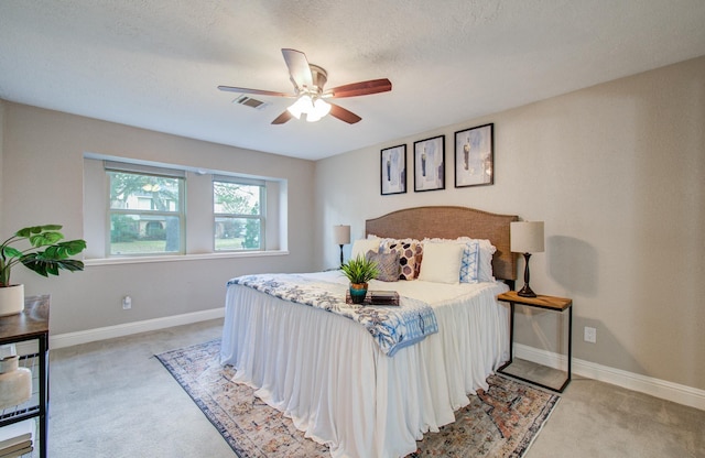 carpeted bedroom featuring a textured ceiling and ceiling fan