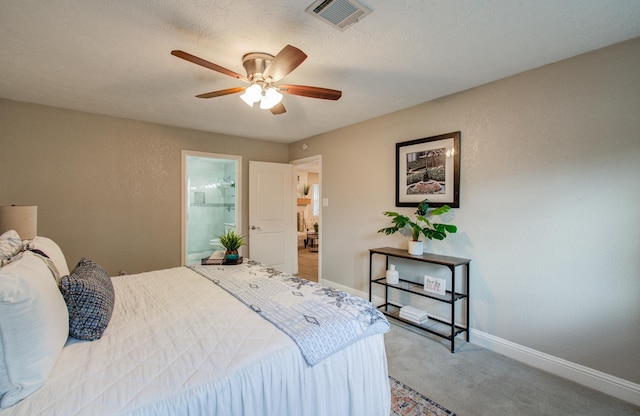 carpeted bedroom featuring ceiling fan, ensuite bathroom, and a textured ceiling