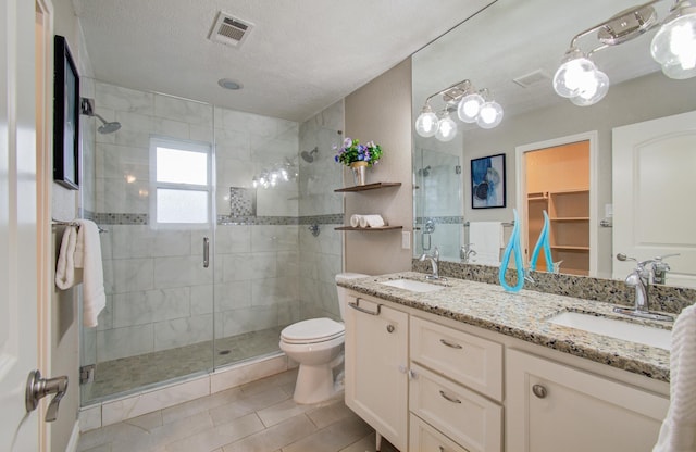 bathroom featuring an enclosed shower, vanity, toilet, and a textured ceiling