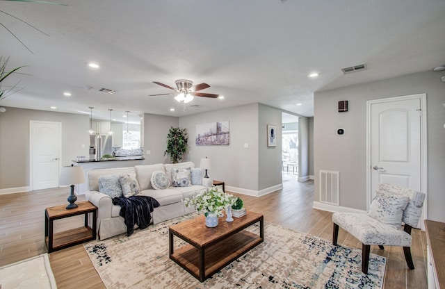 living room with light hardwood / wood-style flooring and ceiling fan