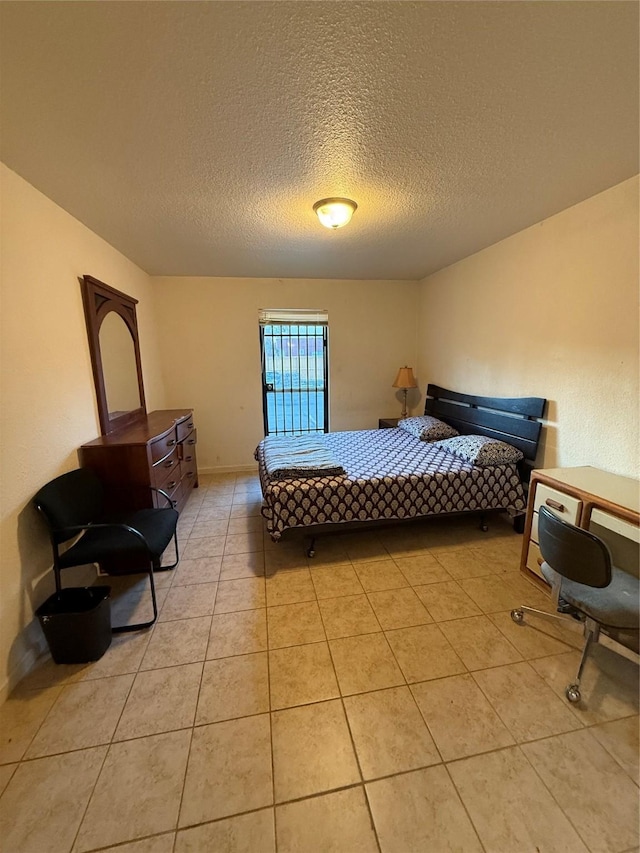 tiled bedroom featuring a textured ceiling