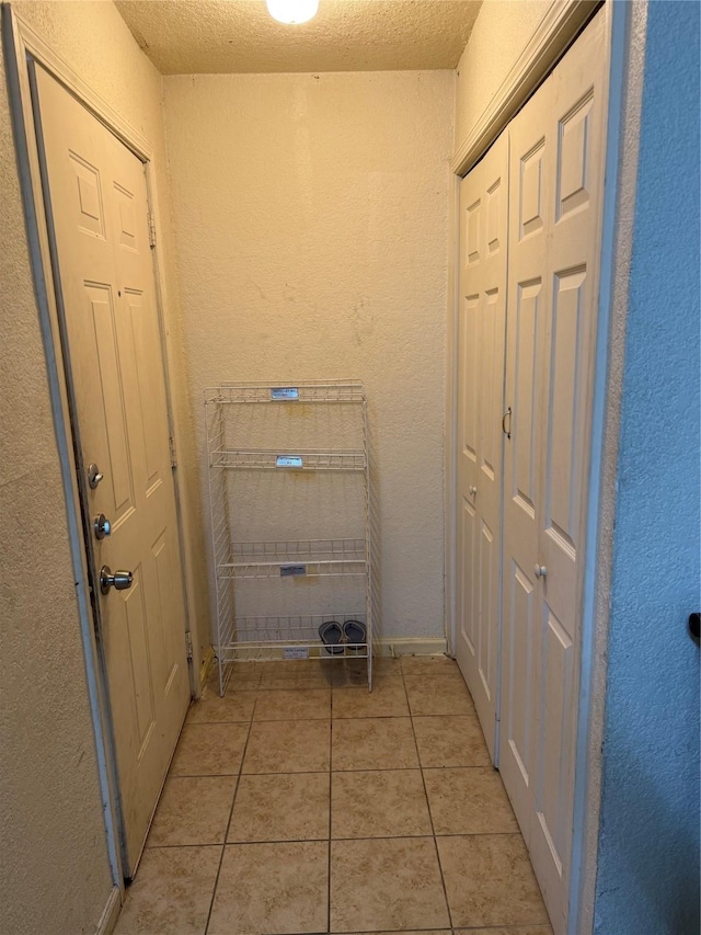 interior space with light tile patterned floors and a textured ceiling