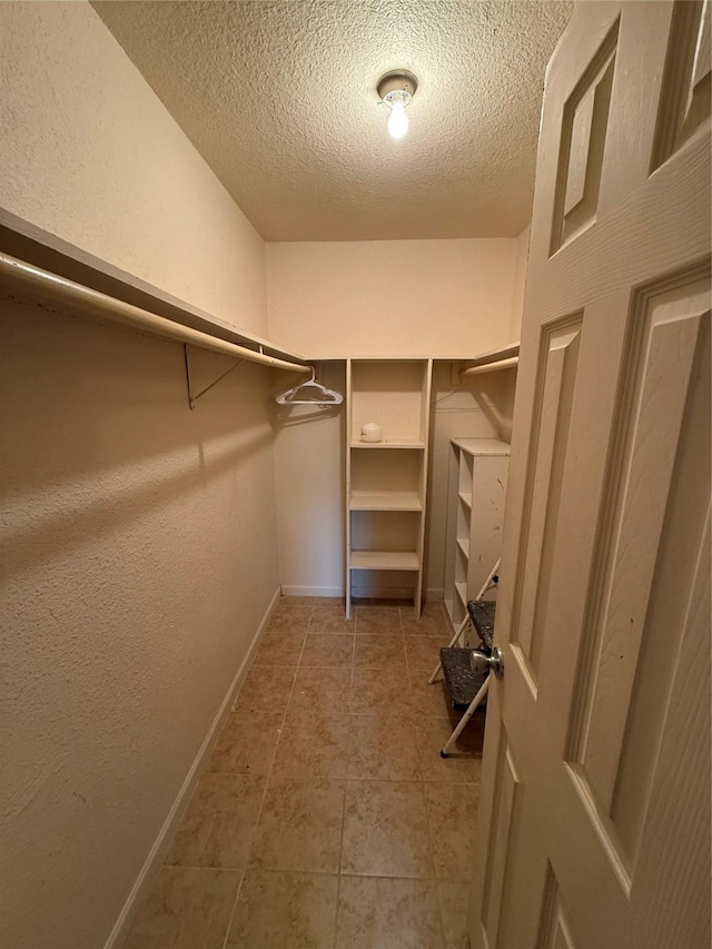 walk in closet with tile patterned floors