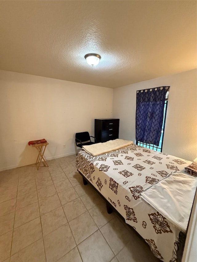 tiled bedroom featuring a textured ceiling