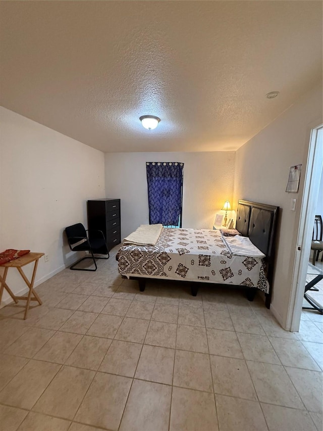 bedroom with light tile patterned flooring and a textured ceiling