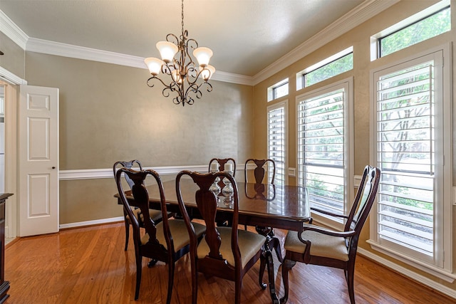 dining space with an inviting chandelier, hardwood / wood-style floors, and ornamental molding