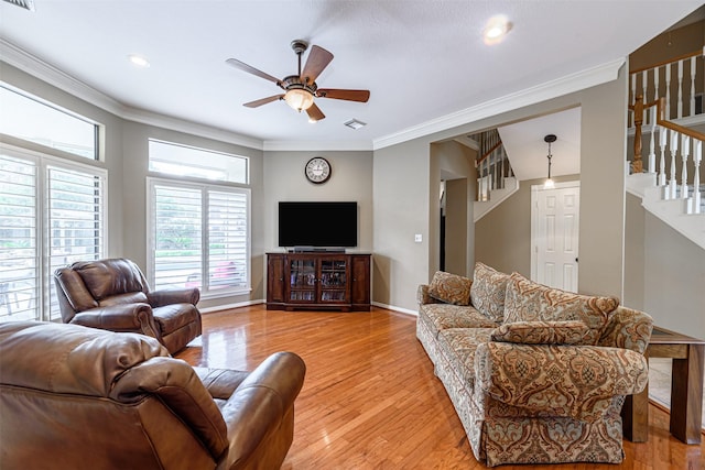 living room with crown molding, ceiling fan, and light wood-type flooring