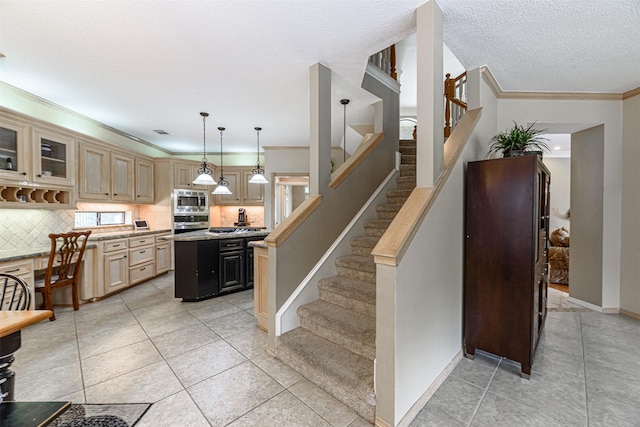 kitchen with pendant lighting, appliances with stainless steel finishes, a center island, tasteful backsplash, and ornamental molding