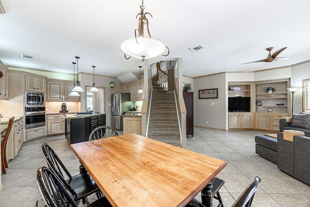 tiled dining area featuring ornamental molding, sink, and ceiling fan