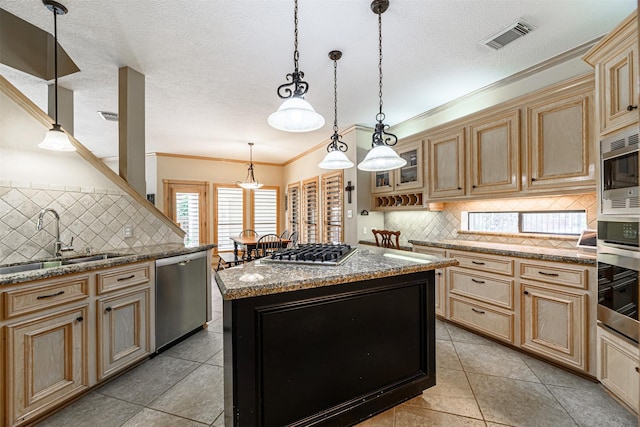 kitchen featuring sink, appliances with stainless steel finishes, hanging light fixtures, light stone counters, and a kitchen island