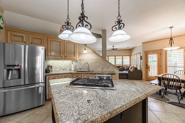 kitchen featuring appliances with stainless steel finishes, decorative light fixtures, sink, decorative backsplash, and light stone countertops