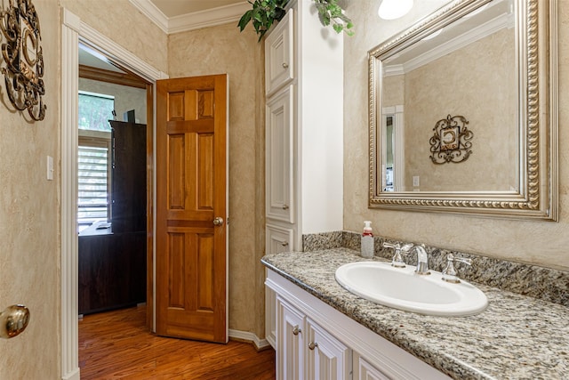 bathroom featuring crown molding, wood-type flooring, and vanity