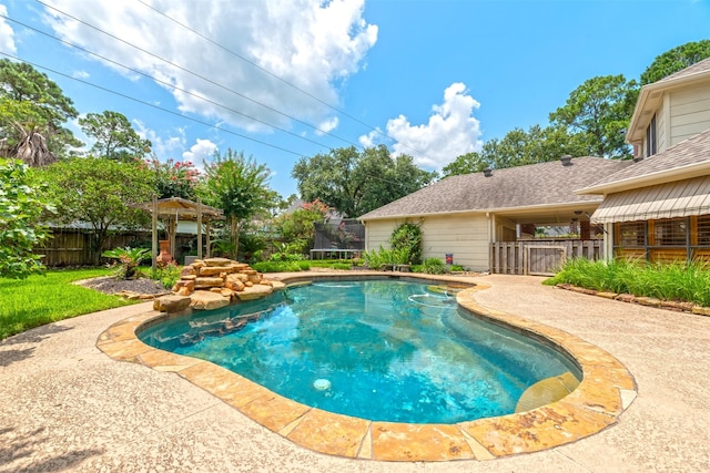 view of swimming pool featuring a trampoline and a patio