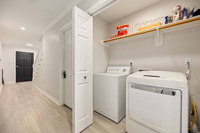 laundry area featuring washing machine and dryer and light wood-type flooring