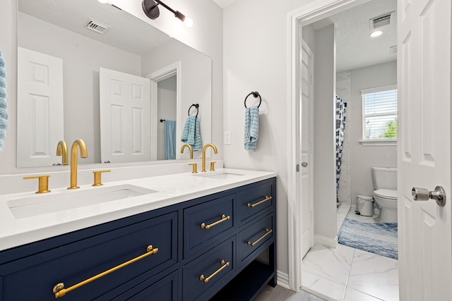 bathroom featuring vanity, toilet, and a textured ceiling