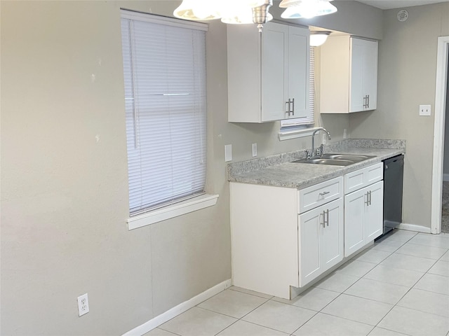 kitchen with dishwasher, white cabinetry, sink, and light tile patterned floors