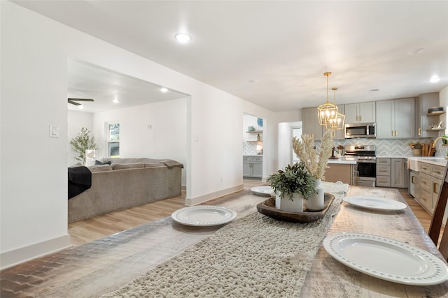 dining room with light hardwood / wood-style flooring, sink, and a chandelier