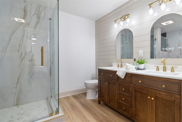 bathroom featuring hardwood / wood-style flooring, toilet, walk in shower, wood walls, and vanity