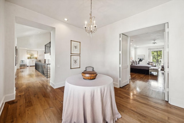 hallway with a chandelier and hardwood / wood-style floors