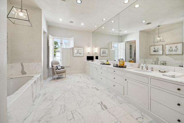 bathroom with vanity and tiled bath