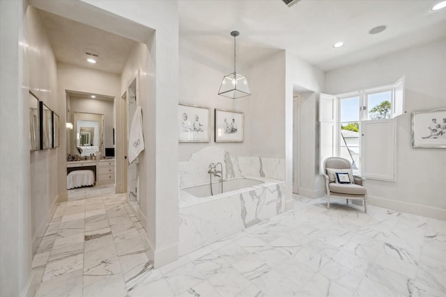 bathroom with vanity and tiled tub