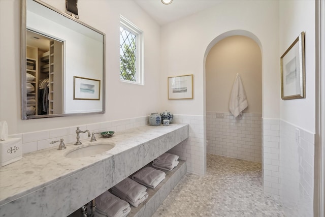 bathroom with tile patterned floors, vanity, and tile walls