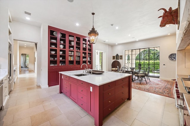 kitchen featuring pendant lighting, sink, and a center island with sink