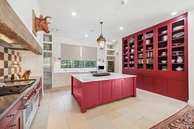 kitchen with pendant lighting, a center island, high quality appliances, light stone counters, and decorative backsplash