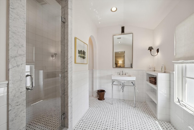 bathroom featuring vaulted ceiling, tile walls, an enclosed shower, and tile patterned floors