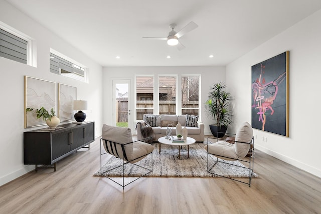 living room with light hardwood / wood-style flooring and ceiling fan