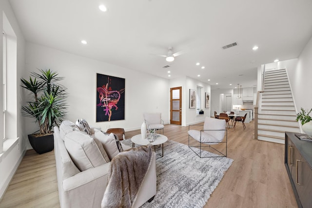 living room featuring ceiling fan and light hardwood / wood-style flooring