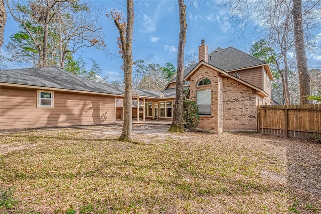 back of property with a lawn and a patio