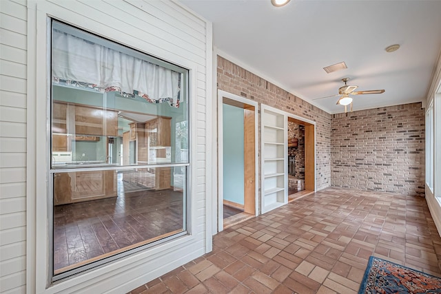 unfurnished sunroom with ceiling fan