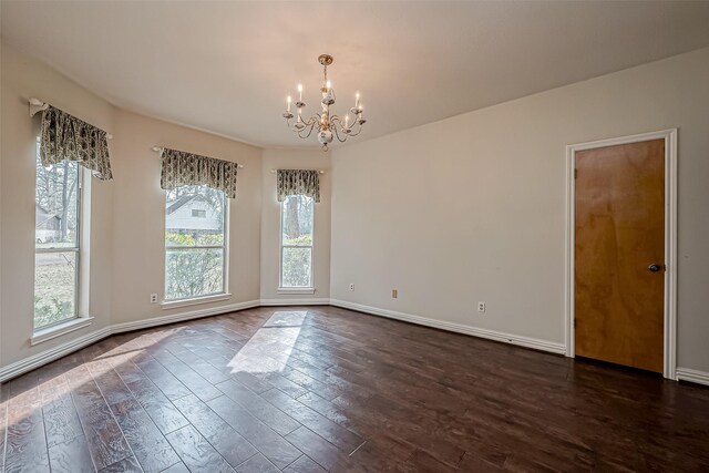 unfurnished room with an inviting chandelier and dark wood-type flooring