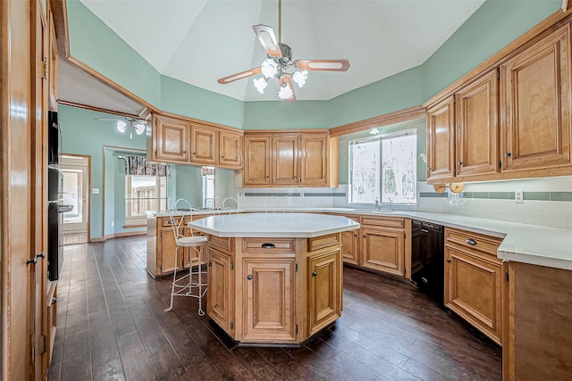 kitchen featuring dark hardwood / wood-style flooring, a center island, dishwasher, and a breakfast bar