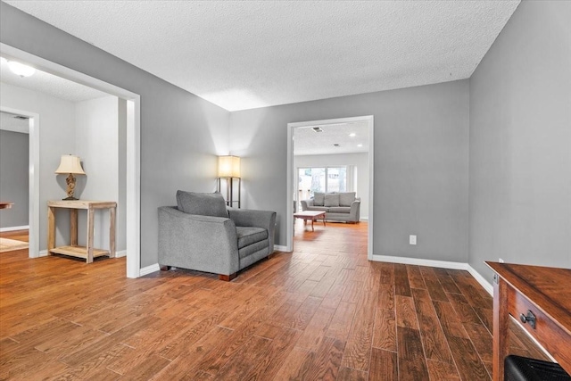 living room featuring dark wood-type flooring and a textured ceiling