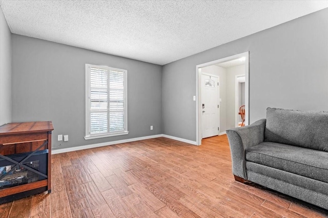 living area with a textured ceiling and light wood-type flooring